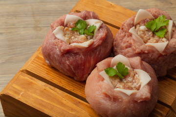Semi-finished meat, seasoned on a wooden background.