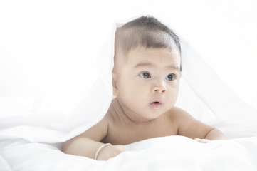 Smiling baby girl lying on a bed