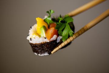 Homemade sushi held with chopsticks