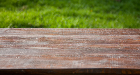 Fototapeta premium wooden picnic tabletop in the garden - summertime background with copy space