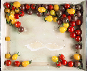 Fresh yellow, red and brown tomatoes from the market in a vintage tray, can be used as background