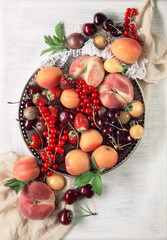 Colorful fruits and berries fresh from the market,
decorated on white wood plate,
free space for your text, can be used as background 