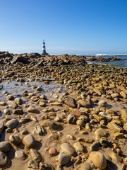 Fototapeta na wymiar lighthouse on the beach, in water, old broken lighthouse, south africa