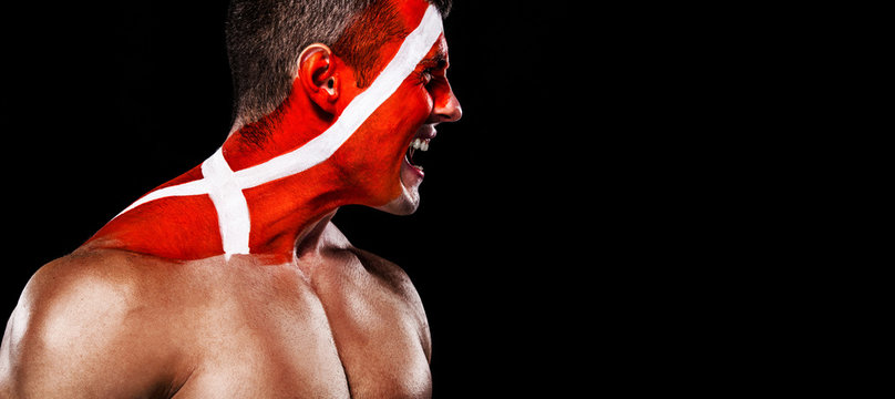 Soccer or football fan with bodyart on face with agression - flag of Denmark.