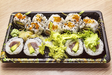 Japanese Cuisine: Tasty Uramaki and Futo Maki served in the take-away box  - selective focus