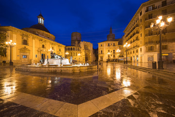 Fountain Rio Turia on Square of the Virgin Saint Mary, Valencia Cathedral, Basilica of Virgen the Helpless at night in Valencia, Spain..
