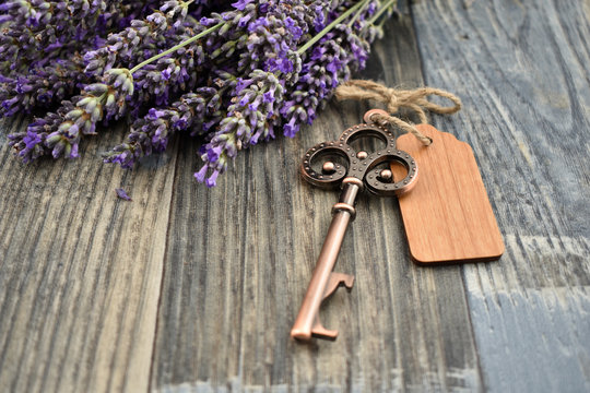 Old key with lavender stock images. Lavender on a wooden background. Decorative metal key images. Romantic key with wooden label. Key on the table