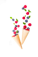 Creative layout with raspberry and blueberry with waffle ice cream cones, simple pattern above copy space