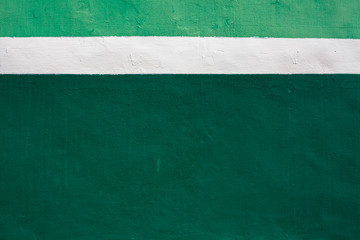 White stripe on green background. Paint smudges on the surface. Painted metal surface. Metal painted in white and green. Space for your text on deformed ..painted metal.
