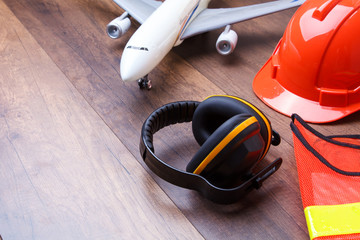 Ear protection on the wooden floor with airplane in back