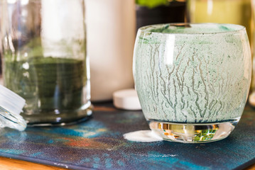 Closeup view emptied glass of fresh kefir probiotik drink mixed with green spirulina powder on...
