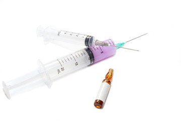 Two medical syringes lie on top of each other with a cross with an ampoule. Equipment for vaccination in laboratories and hospitals