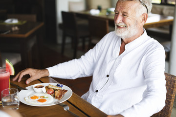 Fototapeta na wymiar Senior man having breakfast at a hotel