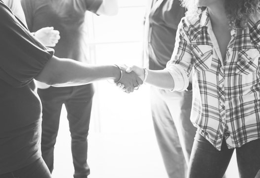 Diverse woman shaking hands together