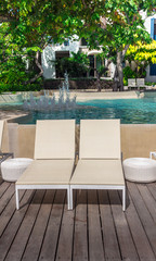 Sunbathing lounger swimming pool side./ Sunbathing lounger swimming pool side and flower pot on summer.
