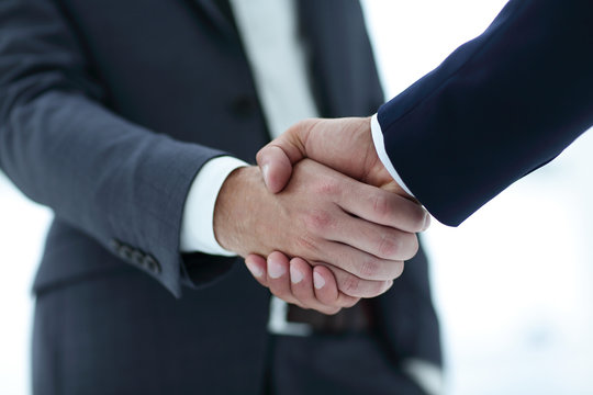 close up of two young male business partner shake hand