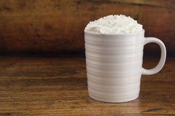 Hot Drink in a Mug with Whipped Cream on a Wooden Table