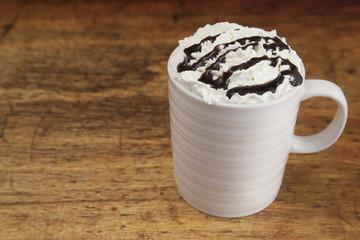 Hot Drink in a Mug with Whipped Cream on a Wooden Table
