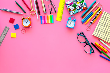 School supplies. Student stationery mockup with glasses and notebook  on pink background top view space for text