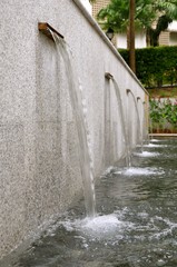 Perspective view of a set of modern water features pouring into a pond