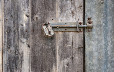 Old bolt and lock on old, weathered door