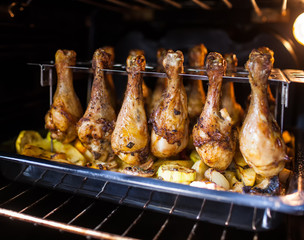Fried chicken thighs inserted into a special stainless steel stand for roasting in the oven