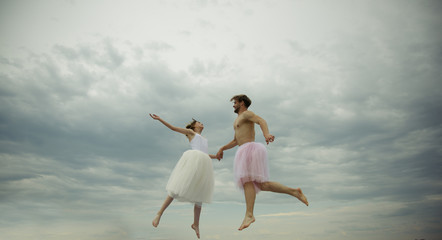 Love is in the air. Young woman and man hold hands in sky. Couple in love fly in clouds. lightness...