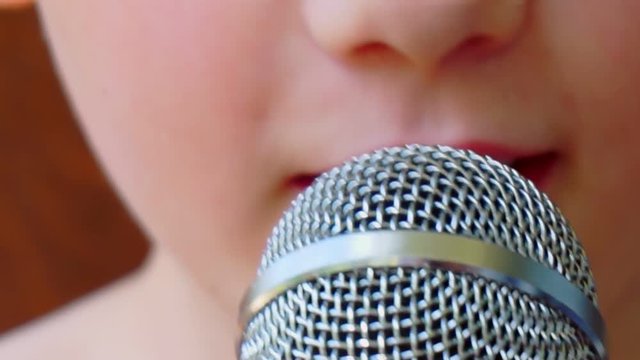child's mouth sings into the microphone.close-up
