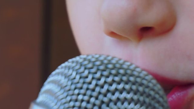 child's mouth sings into the microphone.close-up