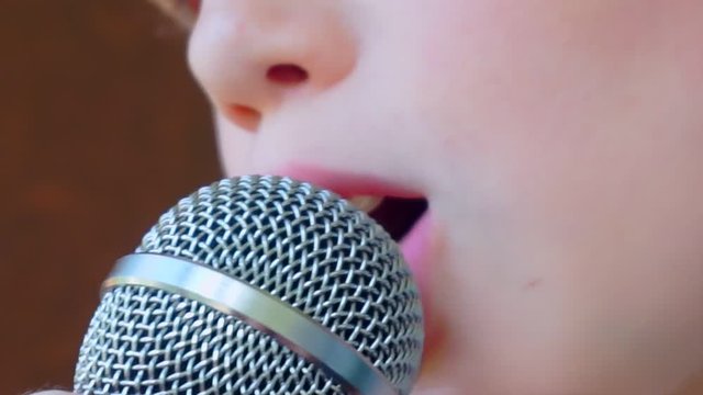child's mouth sings into the microphone.close-up