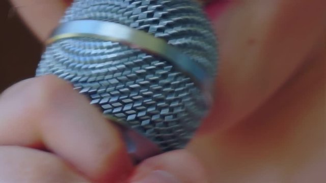 child's mouth sings into the microphone.close-up