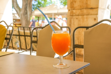 orange juice drink on the beach table, summer fresh cool water for relaxation.fruity smoothies and shakes on table in street city cafe. sweet cold cocktail