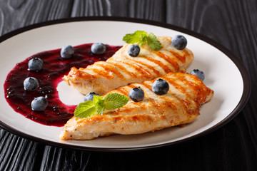 Freshly cooked grilled chicken breast with berry sauce and mint closeup. horizontal