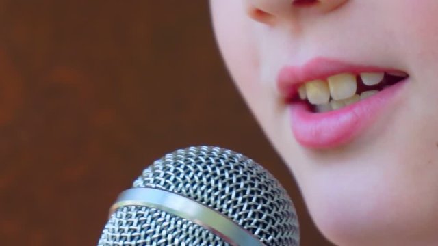 child's mouth sings into the microphone.close-up