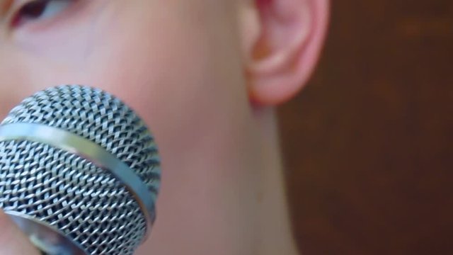 child's mouth sings into the microphone.close-up