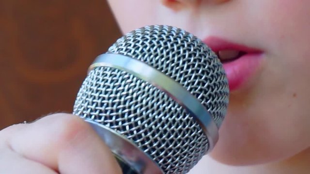 child's mouth sings into the microphone.close-up