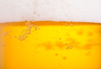 Pouring beer with bubble froth in glass for background. Summer drink texture