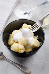 Lazy vareniki with cottage cheese (nioki) with sugar, butter and sour cream. Traditional European cuisine.