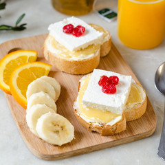 A sandwich with butter, honey and soft cheese. The concept of a healthy and tasty breakfast.