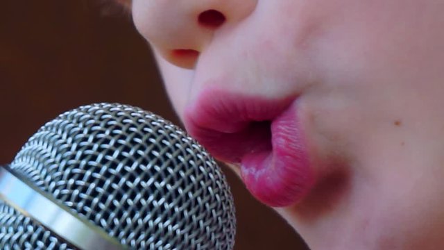mouth of a boy singing into a close-up microphone