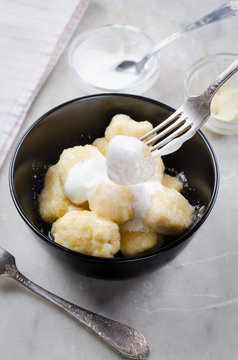 Lazy vareniki with cottage cheese (nioki) with sugar, butter and sour cream. Traditional European cuisine.