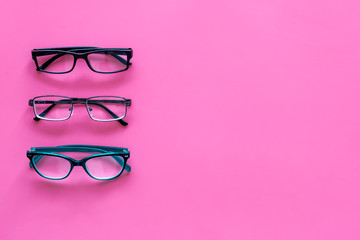 Glasses concept. Set of glasses with different eyeglass frame and transparent lenses on pink background top view copy space pattern