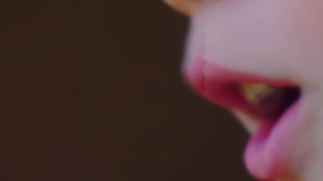 mouth of a boy singing into a close-up microphone