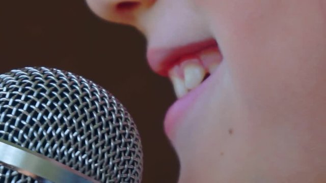 mouth of a child singing into a close-up microphone.