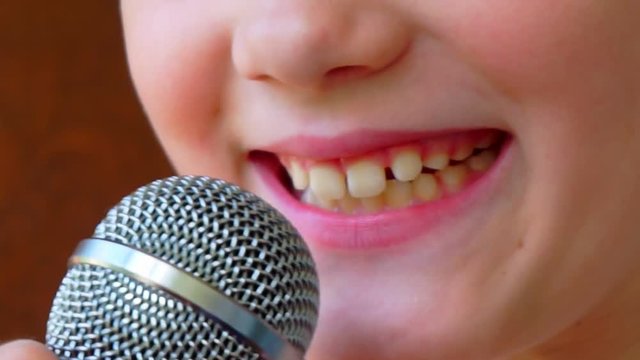mouth of a child singing into a close-up microphone.