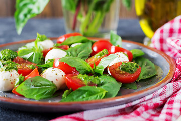 Caprese salad. Healthy meal with cherry tomatoes, mozzarella balls and basil. Home made, tasty food.  Concept for a tasty and healthy vegetarian meal.