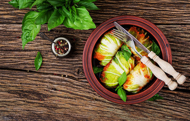 Cabbage rolls stuffed with rice with chicken fillet in tomato sauce on a wooden background. Tasty food. Top view. Flat lay