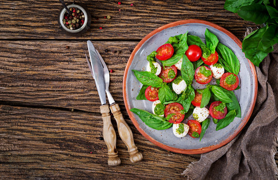 Caprese salad. Healthy meal with cherry tomatoes, mozzarella balls and basil. Home made, tasty food.  Concept for a tasty and healthy vegetarian meal. Top view. Flat lay