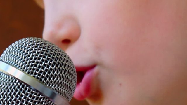 mouth of a child singing into a close-up microphone.