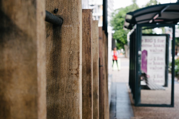 urban street scene, fence, bus shelter and person walking